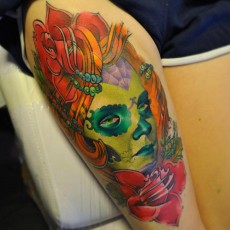 Татуировка в цвете на бицепсе парня - мексиканские черепки