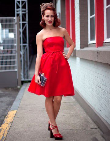 Девушка в красном платье без бретелек и красных туфлях на высоком каблуке