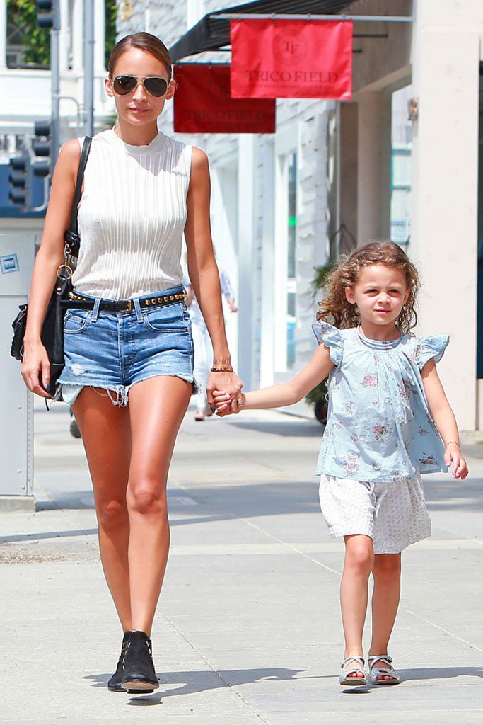 Николь Ричи в коротких джинсовых шортах белом топе идет по улице с дочкой за руку